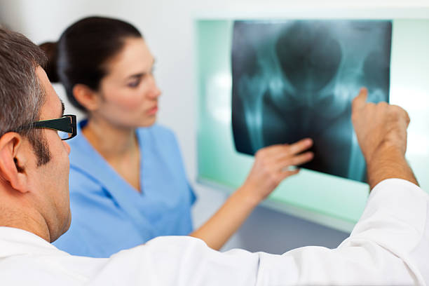 Medical team examining X-ray image of a pelvis in the hospital.