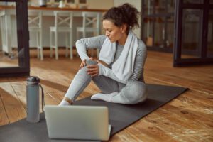 Slim woman hurting knee during online training