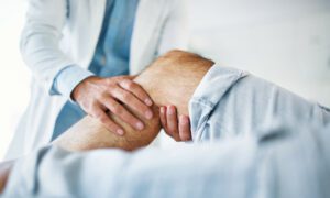 Senior man having knee pain medical exam