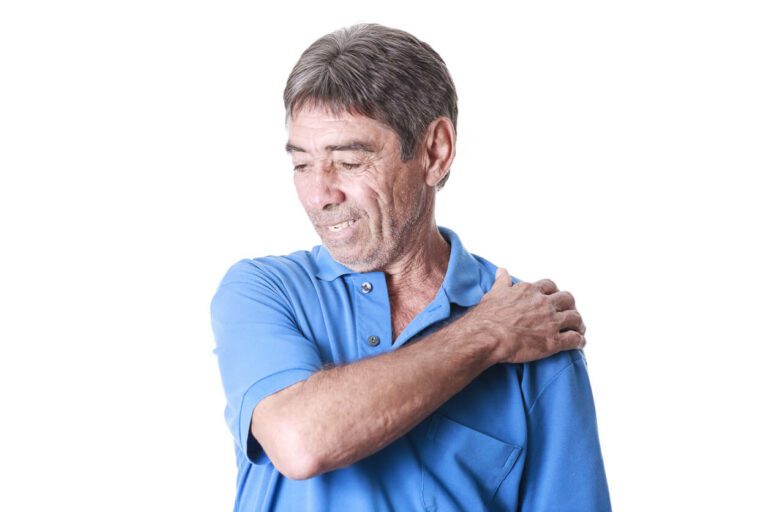 An older man suffering from shoulder pain due to Impingement Syndrome of the Shoulder.