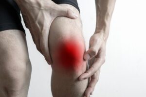 A man puts his hands on his knees due to knee pain.