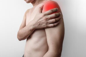 Man has shoulder pain from a torn rotator cuff, and on the shoulder there is an inflamed point from the muscles and tendons in the shoulder.