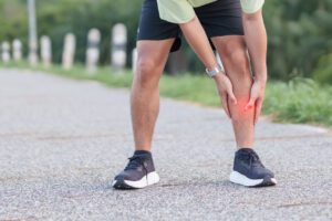 Male runner with sports injuries, shin splints or stress fracture during training.